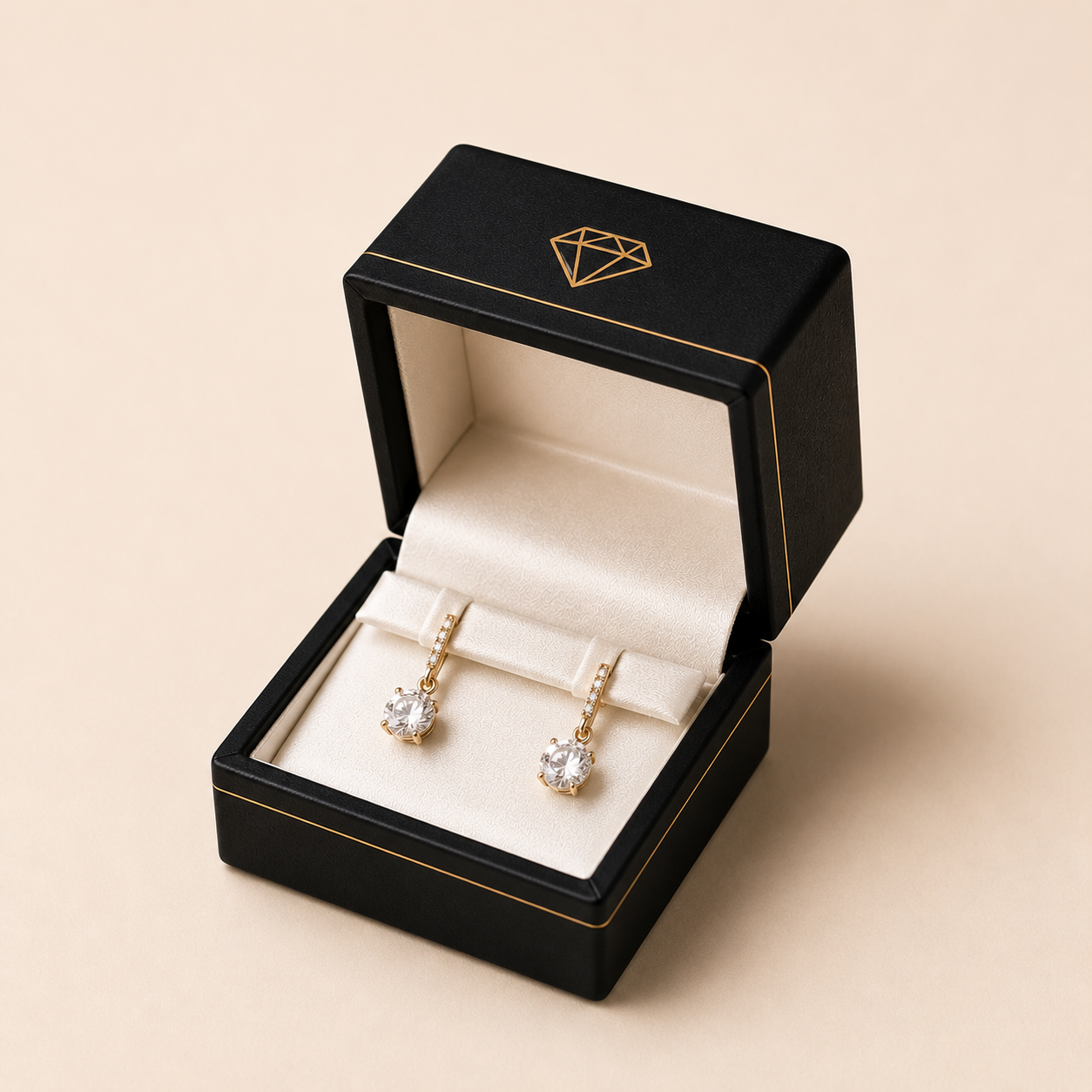 Foil-stamped custom earring box with two gold drop earrings held in a slotted velvet insert